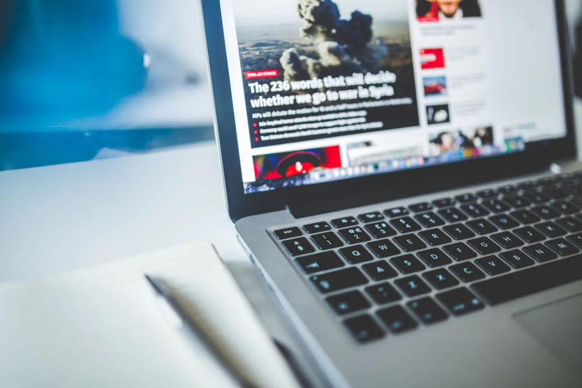 Come scrivere articoli per blog e giornali: scrivania con appunti, taccuino e laptop